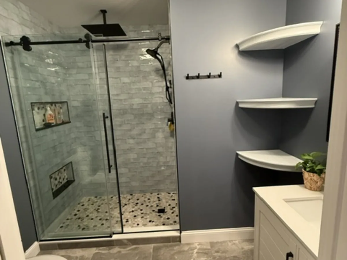 Custom tile shower with hand-laid pebble floor by Oceanside Carpentry